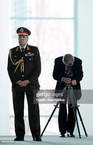 German portrait photographer Konrad R. Mueller , standing next to an Egyptian military officer, checks his camera as he waits for the arrival of...