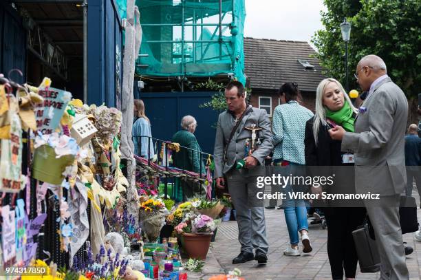 Man holds a crucifix outside the Methodist Church near the Grenfell Tower as community of survivors, bereaved families and members of the public...