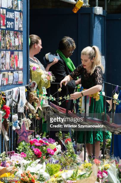 Woman fixes origami peace doves outside the Methodist Church near the Grenfell Tower as community of survivors, bereaved families and members of the...