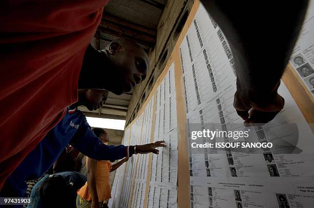 Voters in Abidjan look on November22, 2009 at the provisional electoral list for the Ivory coast presidential elections which have been posted in...