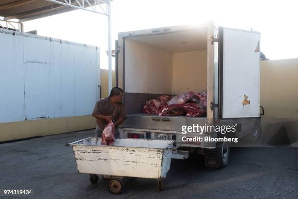 Worker loads pork into a truck for delivery at the Obrador Muoz meat wholesale and distribution center in San Luis Potosi, Mexico, on Friday, June 8,...