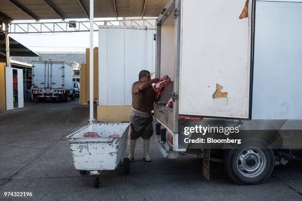 Worker loads pork into a truck for delivery at the Obrador Muoz meat wholesale and distribution center in San Luis Potosi, Mexico, on Friday, June 8,...