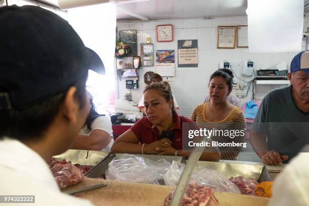 Customers stand in line to order meat at La Nueva Fortuna butcher shop in San Luis Potosi, Mexico, on Friday, June 8, 2018. Mexico will begin to tax...