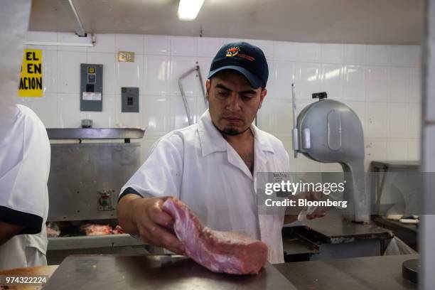 Worker prepares pork for sale at La Nueva Fortuna butcher shop in San Luis Potosi, Mexico, on Friday, June 8, 2018. Mexico will begin to tax a range...