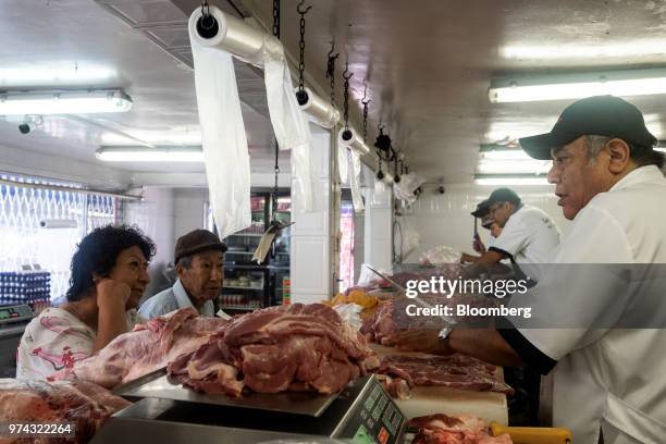 Worker assists customers with a purchase at La Nueva Fortuna butcher shop in San Luis Potosi, Mexico, on Friday, June 8, 2018. Mexico will begin to...