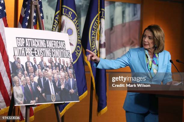 Democratic Minority Leader Nancy Pelosi speaks about health care as she points to a picture of President Trump with House GOP members, during her...