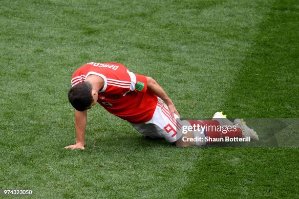 Alan Dzagoev of Russia holds his leg as he goes down injured during the 2018 FIFA World Cup Russia Group A match between Russia and Saudi Arabia at...