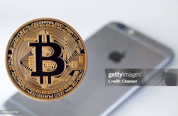 In this photo illustration, a visual representation of the Bitcoin Digital Cryptocurrency sits on display in front of an Apple iPhone 6 on June 14,...