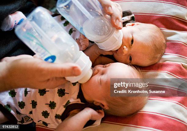 twin babies being fed, sweden. - sisters feeding stock pictures, royalty-free photos & images