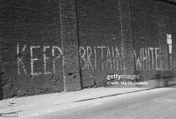 Racist graffiti in white paint on brick wall in Canning Town near the River Lee: