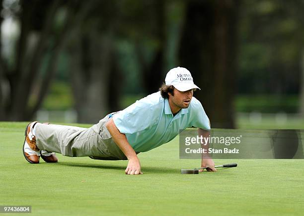 Nathan J. Smith lowers his body to get a better read for his putt at the 13th green during the first round of the Pacific Rubiales Bogota Open...