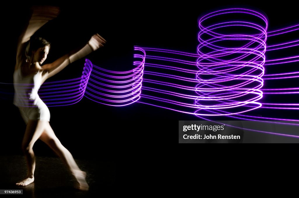 Ballerina dances in purple graphic abstract light 