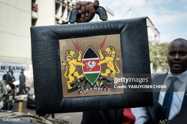 Kenya's Cabinet Secretary for National Treasury Henry Rotich poses with the budget briefcase before leaving for Parliament to read the budget speech...