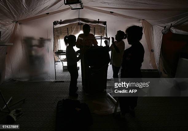Peruvian volunteers prepare a campaign hospital donated by their government in Concepcion, Chile on March 04, 2010. The official death toll from...