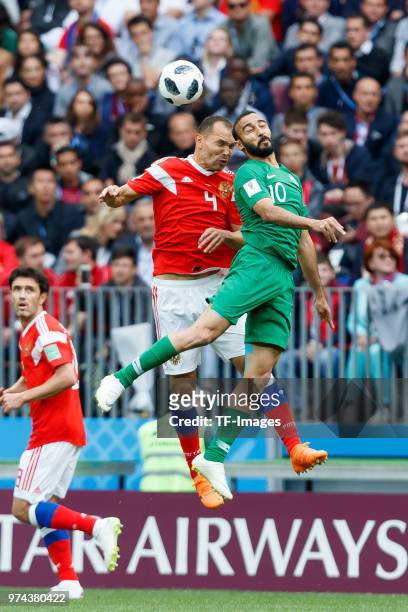 Sergey Ignashevich of Russia and Mohammed Al-Sahlawi of Saudi Arabia battle for the ball during the 2018 FIFA World Cup Russia group A match between...