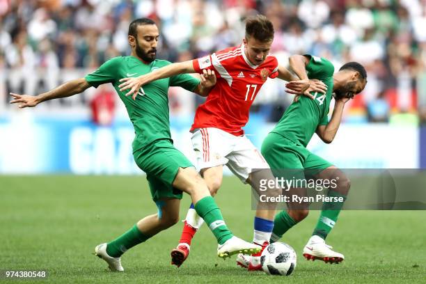 Fedor Smolov of Russia controls the ball under pressure of Mohammed Alsahlawi and Abdullah Otayf of Saudi Arabia during the 2018 FIFA World Cup...