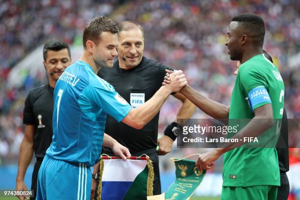 Russia captain Igor Akinfeev shakes hands and exchanges pendants with Saudi Arabia captain Osama Hawsawi prior to the 2018 FIFA World Cup Russia...