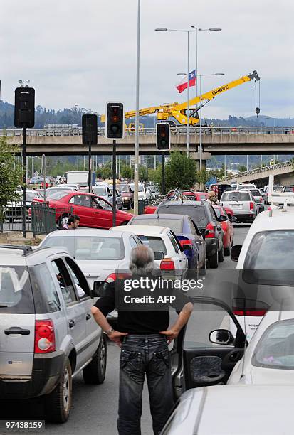 Man observes as works repair a bridge in Concepcion, Chile, on March 4, 2010. The official death toll from Saturday's 8.8-magnitude earthquake in...