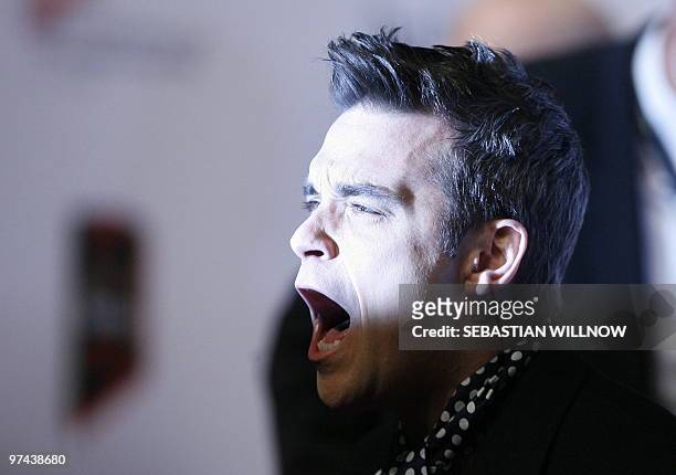 British singer Robbie Williams poses for photographers as he arrives on the red carpet for the "Echo" music awards in Berlin on March 4, 2010. AFP...