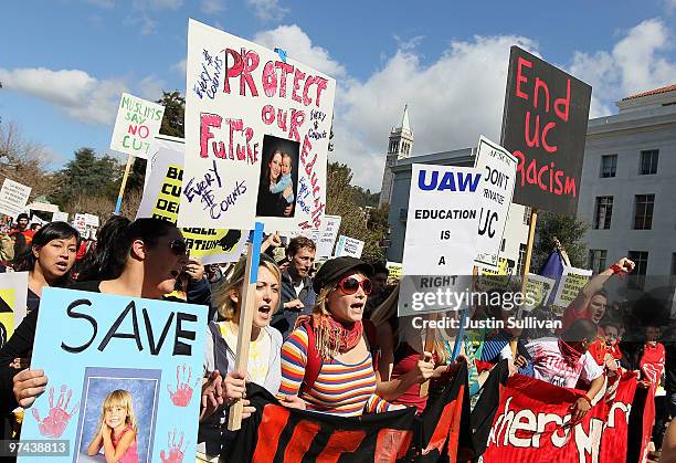 Students at UC Berkeley carry signs as they march through campus during a national day of action against funding cuts and tuition increases March 4,...