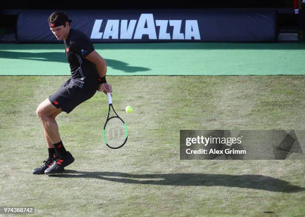 Milos Raonic of Canada plays the ball behind the back during his match against Marton Fucsovics of Hungary during day 4 of the Mercedes Cup at...