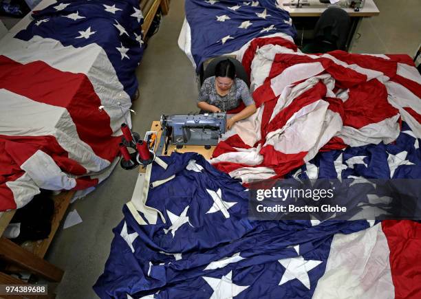 Thuy Nguyen repairs an American flag at Accent Banner and Flags in Medford, MA on June 12, 2018. The small family business specializes in custom...