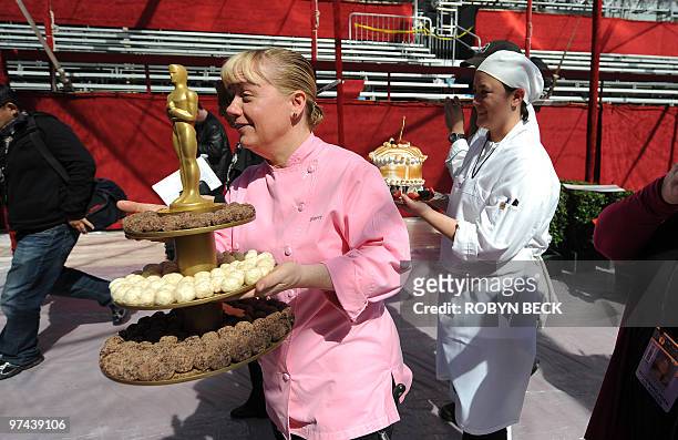 Executive pastry chef Sherry Yard walks on the red carpet with a display of deserts planned for the Governors Ball during a preview of the food and...