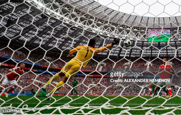 Russia's midfielder Yuri Gazinskiy scoring the opening goal past Saudi Arabia's goalkeeper Abdullah Al-Mayouf during the Russia 2018 World Cup Group...