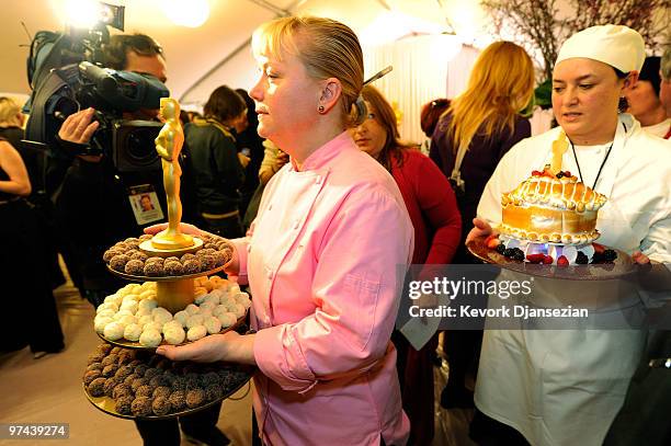 Sherry Yard, left, executive pastry chef of the Governors Ball, holding a tray with chocolate balls and a golden chocolate Oscar statue leaves after...