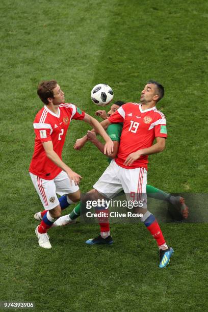 Salem Aldawsari of Saudi Arabia is challenged by Mario Fernandes and Alexandr Samedov of Russia during the 2018 FIFA World Cup Russia Group A match...