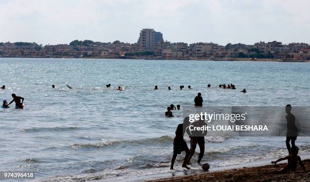 Syrian people enjoy the sea in Latakia on June 14, 2018.