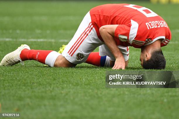 Russia's midfielder Alan Dzagoev reacts due to an injury during the Russia 2018 World Cup Group A football match between Russia and Saudi Arabia at...