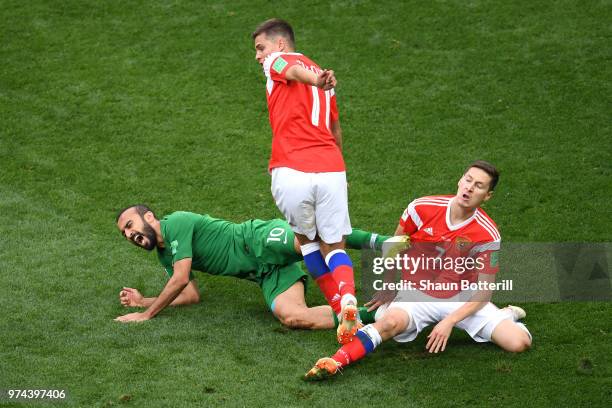 Mohammed Alsahlawi of Saudi Arabia is tackled by Roman Zobnin and Daler Kuziaev of Russia during the 2018 FIFA World Cup Russia Group A match between...