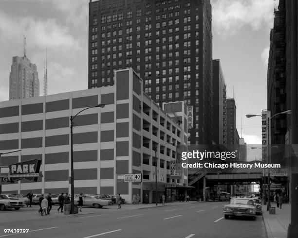 View of Wells Street, near a parking garage, and the El train platform in the distance, in the Loop neighborhood of Chicago, 1967.