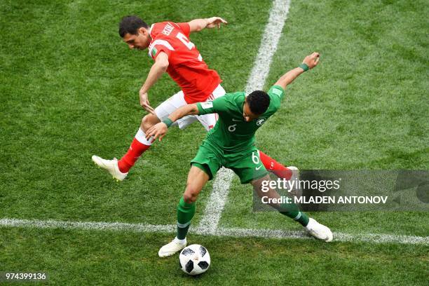 Russia's defender Andrey Semenov and Saudi Arabia's defender Mohammed Al-Breik compete for the ball during the Russia 2018 World Cup Group A football...