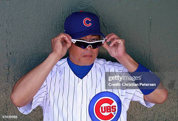 Kosuke Fukudome of the Chicago Cubs puts on his glasses in the dugout before the MLB spring training game against the Oakland Athletics at HoHoKam...