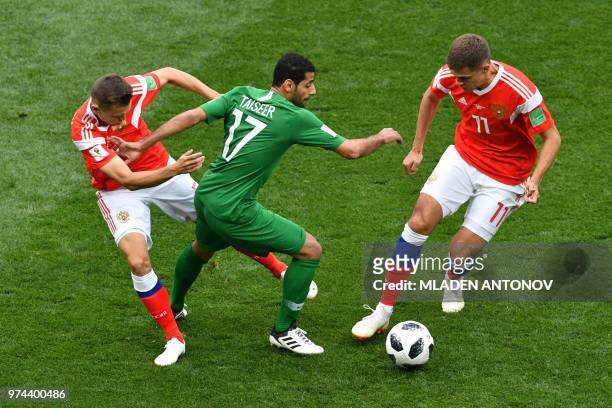 Russia's defender Andrey Semenov and midfielder Roman Zobnin compete for the ball with Saudi Arabia's midfielder Taisir Al-Jassim during the Russia...