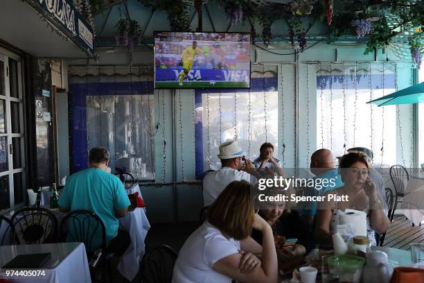 The opening soccer match of the 2018 FIFA World Cup plays at a restaurant in Russian enclave Brighton Beach June 14, 2018 in the Brooklyn borough of...