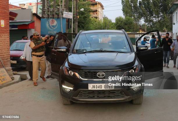 Police inspect damaged car of senior journalist Shujaat Bukhari, who was shot dead by unidentified gunmen outside his office at Press Colony, on June...