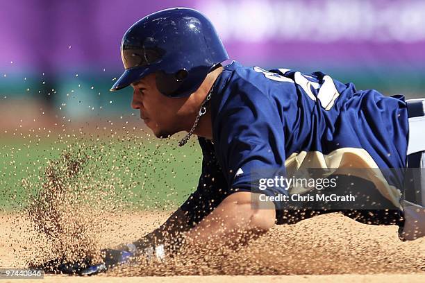 Carlos Gomez of the Milwaukee Brewers slides into second base against the San Francisco Giants during a spring training game at Scottsdale Stadium on...