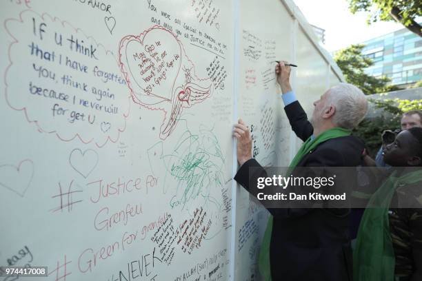 Leader of the Labour Party, Jeremy Corbyn writes on a memorial wall by Grenfell Tower on the one year anniversary of the Grenfell Tower fire on June...