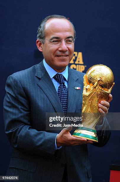 Felipe Calderon Hinojosa, President of Mexico, holds the FIFA World Cup trophy at the Official Residence of Los Pinos as part of its world tour on...