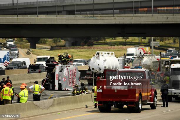Firefighters work to recover fuel from a rollover crash on Interstate 25 that caused a hazardous materials fuel spill that closed all lanes of...