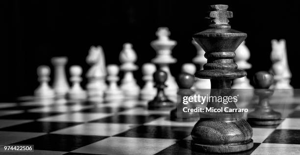 king chess piece on chessboard - chess king piece stock pictures, royalty-free photos & images