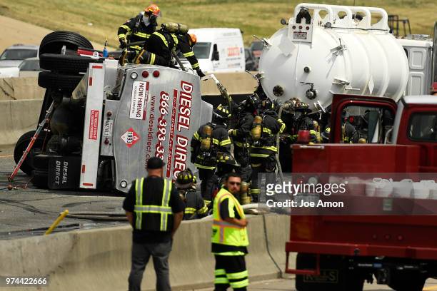 Firefighters work to recover fuel from a rollover crash on Interstate 25 that caused a hazardous materials fuel spill that closed all lanes of...
