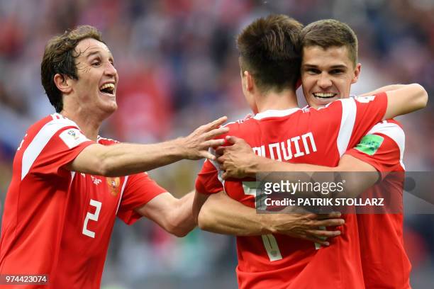 Russia's midfielder Aleksandr Golovin celebrates scoring his team's fifth goal with Russia's midfielder Roman Zobnin and Russia's defender Mario...