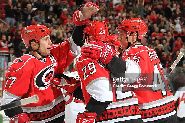 Rod Brind'Amour and Alexandre Picard of the Carolina Hurricanes congratulate teammate Tom Kostopoulos on his first period goal a NHL game against the...