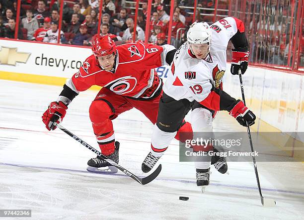 Tim Gleason of the Carolina Hurricanes and Jason Spezza of the Ottawa Senators battle for the puck during a NHL game on March 4, 2010 at RBC Center...