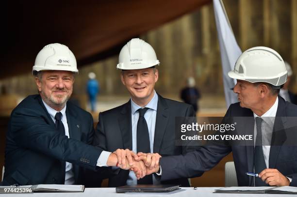French Economy Minister Bruno Le Maire shakes hands with MSC Cruise executive chairman Italy's Pierfrancesco Vago and shipyard STX France CEO Laurent...