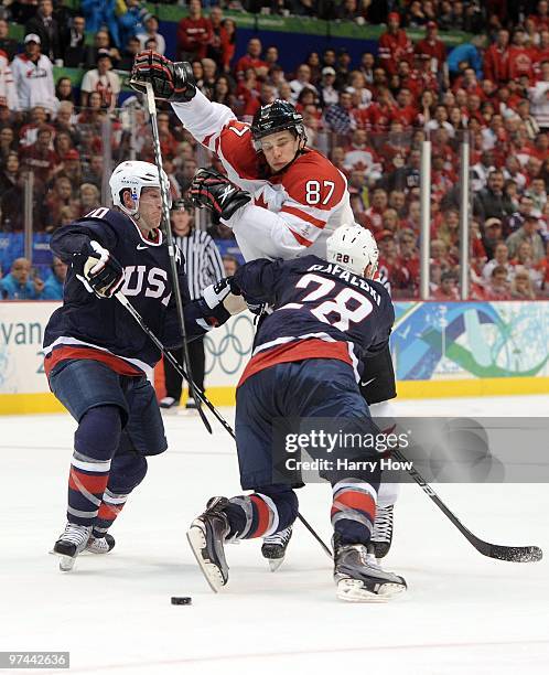 Brian Rafalski and Ryan Suter of USA play the body against Sidney Crosby of Canada in the first overtime during the ice hockey men's gold medal game...